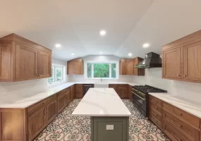 Modern kitchen after remodel in Elma, NY, showcasing custom cabinets, bright recessed lighting, and bold patterned tile flooring.