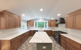 Modern kitchen after remodel in Elma, NY, showcasing custom cabinets, bright recessed lighting, and bold patterned tile flooring.