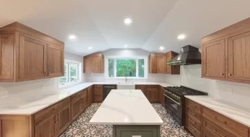 Modern kitchen after remodel in Elma, NY, showcasing custom cabinets, bright recessed lighting, and bold patterned tile flooring.