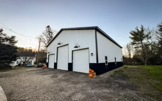 Landscape view of a Stately Pole Barns’ modern pole barn blending seamlessly into Holland, NY’s serene countryside.