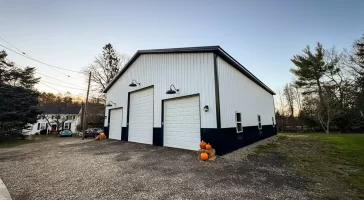 Landscape view of a Stately Pole Barns’ modern pole barn blending seamlessly into Holland, NY’s serene countryside.