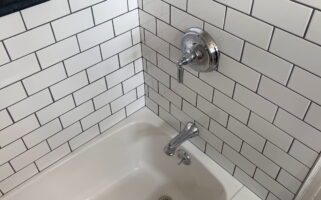 Chrome fixtures and expertly-installed subway tile by Stately Kitchen and Bath in Kenmore, NY.