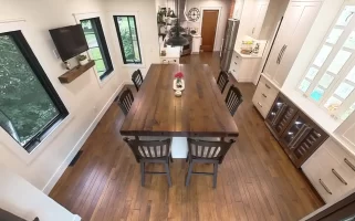 Aerial view of remodeled kitchen and dining area with wooden island and elegant lighting in Amherst, NY by Stately Kitchen and Bath.