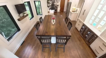 Aerial view of remodeled kitchen and dining area with wooden island and elegant lighting in Amherst, NY by Stately Kitchen and Bath.