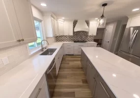 Spacious and modern kitchen remodel in Clarence, NY featuring white shaker cabinets, quartz countertops, and stainless steel appliances completed by Stately Kitchen & Bath.