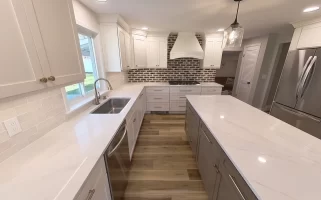 Spacious and modern kitchen remodel in Clarence, NY featuring white shaker cabinets, quartz countertops, and stainless steel appliances completed by Stately Kitchen & Bath.