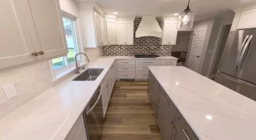 Spacious and modern kitchen remodel in Clarence, NY featuring white shaker cabinets, quartz countertops, and stainless steel appliances completed by Stately Kitchen & Bath.