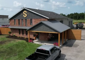 Full view of Stately Builders' Clarence Center office after exterior remodel, featuring new siding, signage, and improved landscaping.