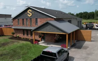 Full view of Stately Builders' Clarence Center office after exterior remodel, featuring new siding, signage, and improved landscaping.