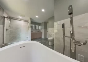 A wide-angle view from the bathtub looking toward the shower and vanity in a modern bathroom remodel by Stately Kitchen and Bath with a clean, minimalist design.