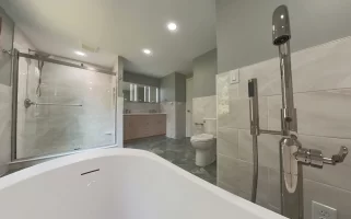 A wide-angle view from the bathtub looking toward the shower and vanity in a modern bathroom remodel by Stately Kitchen and Bath with a clean, minimalist design.