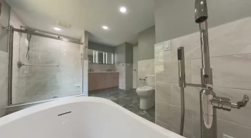 A wide-angle view from the bathtub looking toward the shower and vanity in a modern bathroom remodel by Stately Kitchen and Bath with a clean, minimalist design.