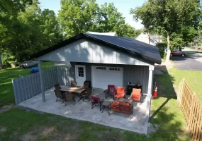 Rear view of a 24x36x10 pole barn in Clarence, NY, showcasing the extended outdoor pavilion area, constructed by Stately Pole Barns.