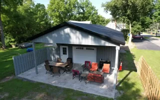 Rear view of a 24x36x10 pole barn in Clarence, NY, showcasing the extended outdoor pavilion area, constructed by Stately Pole Barns.