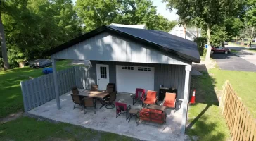 Rear view of a 24x36x10 pole barn in Clarence, NY, showcasing the extended outdoor pavilion area, constructed by Stately Pole Barns.