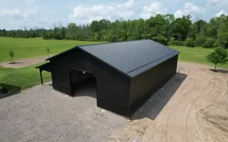 Overhead shot of a matte black pole barn built by Stately Pole Barns in Clarence, NY, featuring strong structural design with Everlast II Steel Panels and a spacious interior.